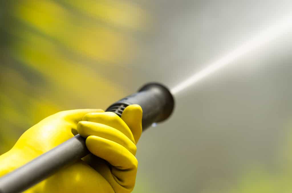 Closeup black head of high pressure water cleaner as waterbeam emerges. 5 Reasons to Make Pressure Washing Pollen Away a Priority