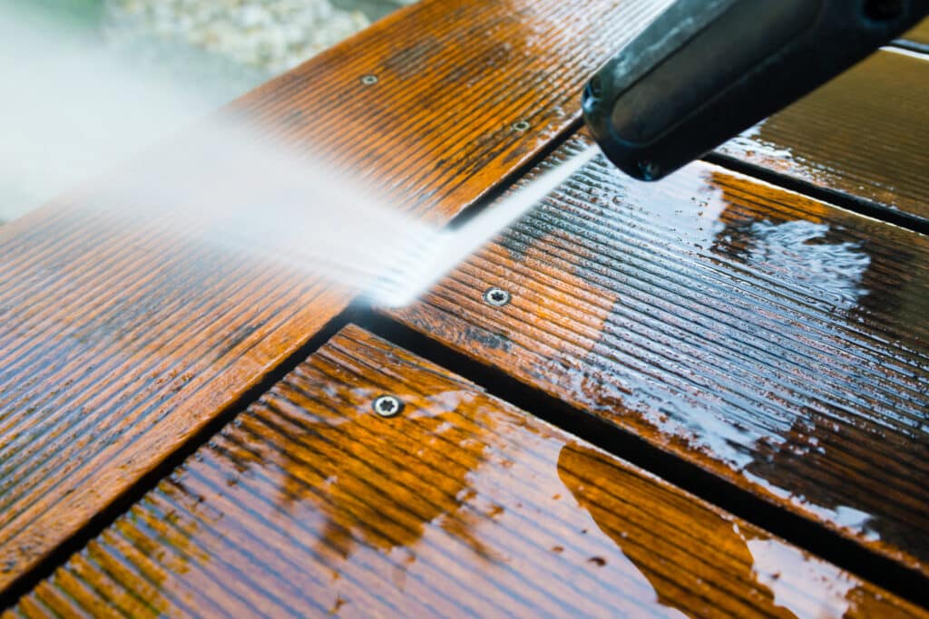 cleaning terrace with a power washer - high water pressure cleaner on wooden terrace surface. A Complete Guide to Understanding Wood Rot